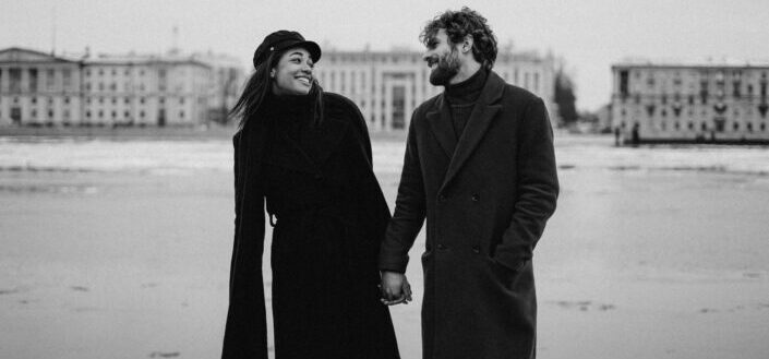 Couple Smiling While Holding Hands at the Beach