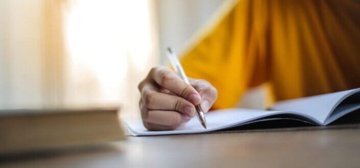 Person writing on a notebook