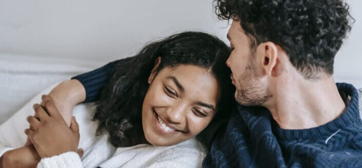 Smiling Couple Cuddling on the Couch