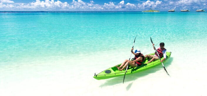Two People Riding a Green Kayak