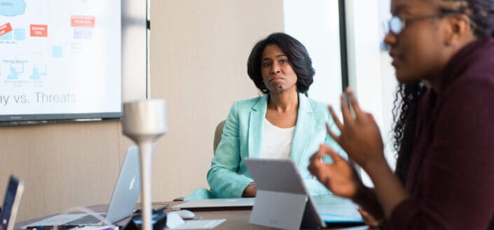 Woman Wearing Teal Dress Shirt In Meeting