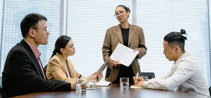 Woman Presenting in Front of Colleagues Meeting