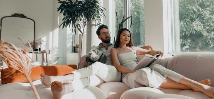 man and women sitting on white couch