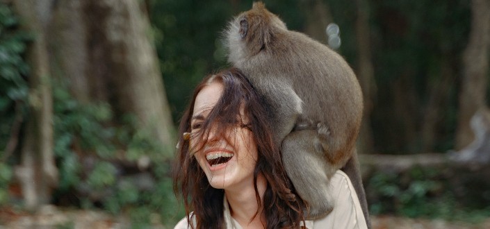 happy woman has monkey on her shoulder