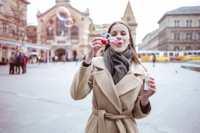 Woman in Brown Coat Blowing Bubbles - Jokes for Kids