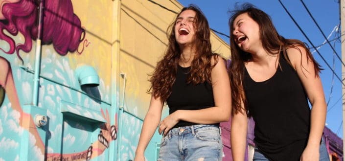 girls laughing hard while walking