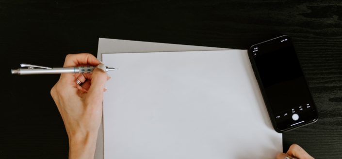 person about to write on piece of paper