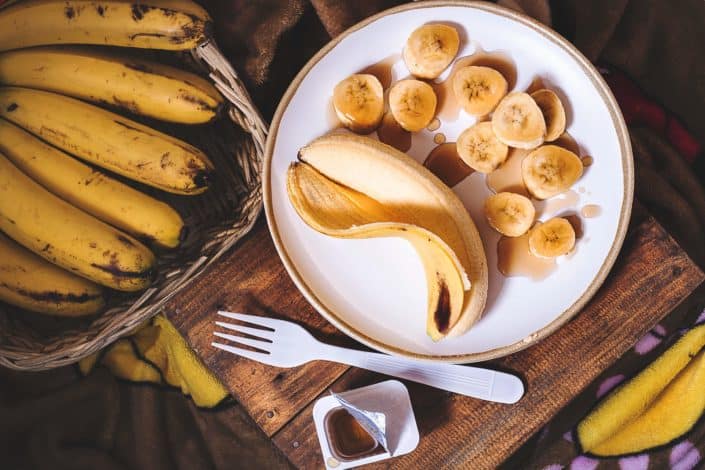 Peeled and sliced bananas on a plate.