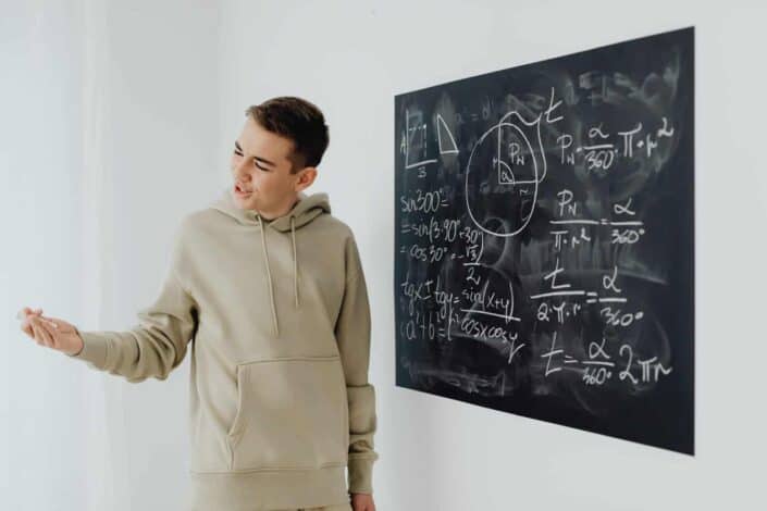 boy smiling beside the blackboard