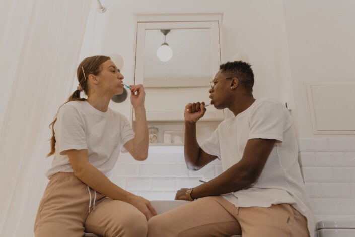 A couple brushing their teeth together