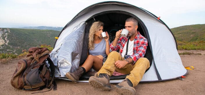 Couple Sitting in the Tent Drinking Coffee