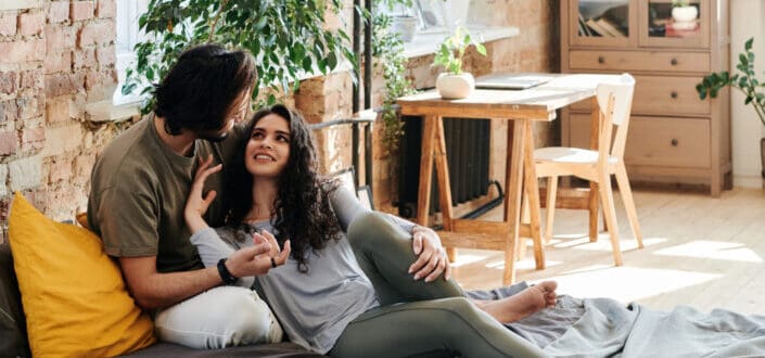 A couple hugging while sitting on bed