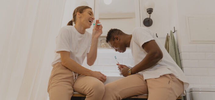 Happy Man and Woman Brushing Their Teeth Together