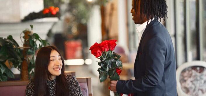 man presenting a woman red roses