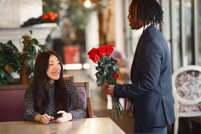 Man Giving a Woman a Bunch of Red Roses