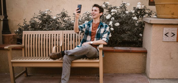 man sitting on the bench using smartphone