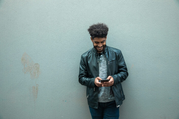 A man smiling while texting