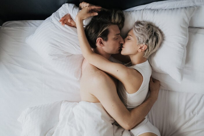 A romantic couple kissing on the bed