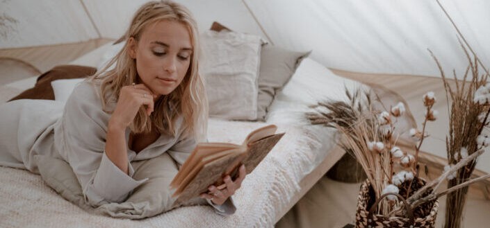 lady reading a book near dried flowers