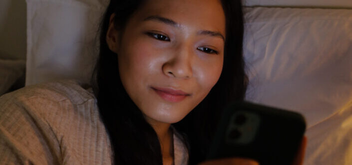 A woman using her cellphone in bed