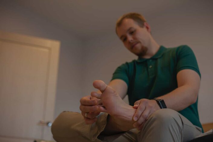 A guy massaging his own foot 