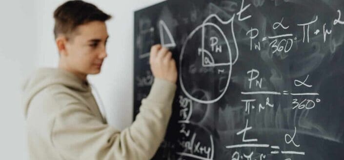 Boy solving an equation on a blackboard