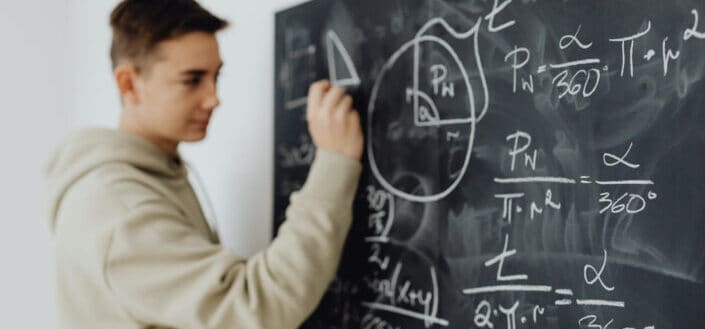 Boy solving an equation on a blackboard