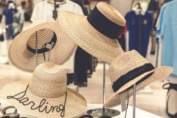 Rustic, fashionable hats in a mall display stand.