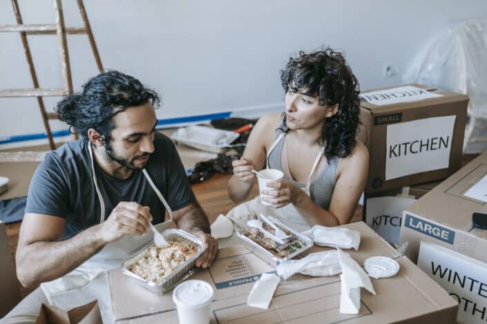 Couple Eating on the Floor While Packing