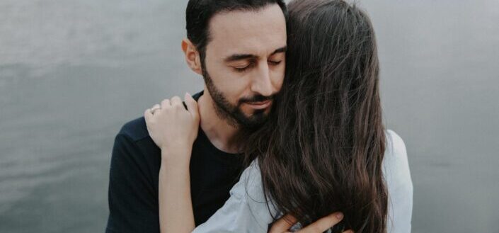 Couple hugging by the lake