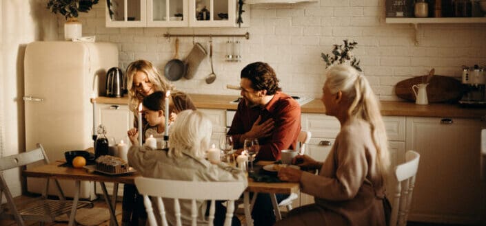 Family Sits on Table Inside Kitchen