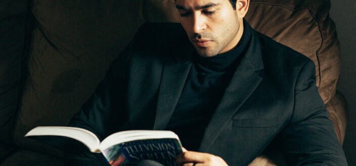 Formal masculine male with book on couch