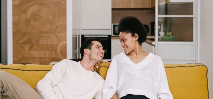 Happy couple sitting on yellow couch