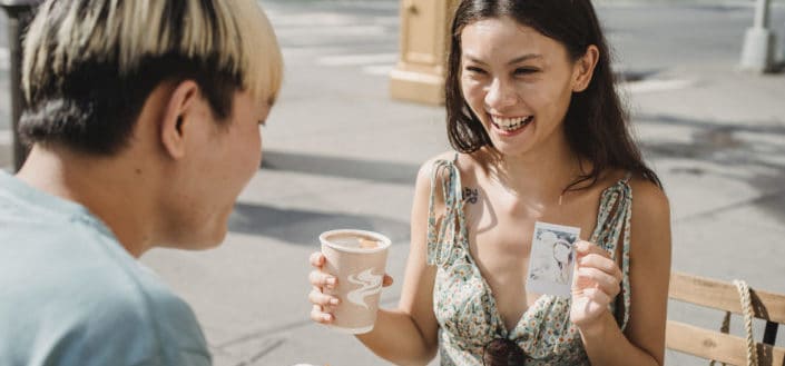 A woman showing polaroid to a man