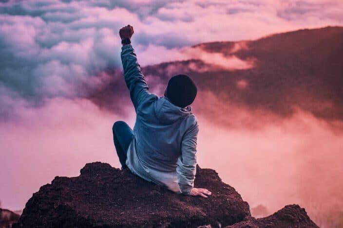 Man celebrating while on a mountain top