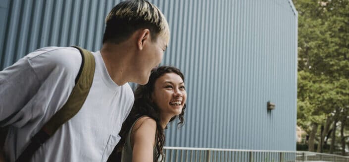 Teenagers Laughing Near Fence in the City