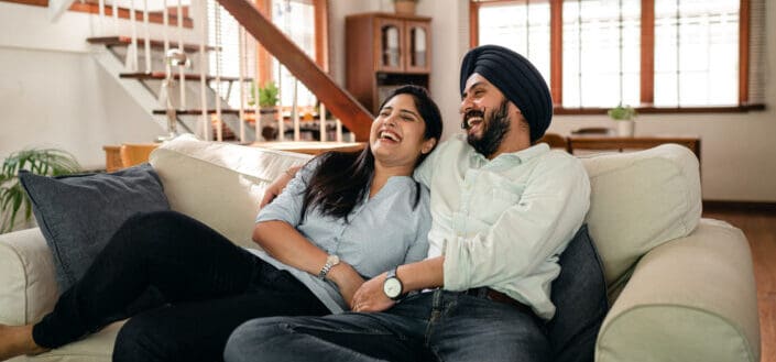 Couple having a good laugh while sitting on their couch