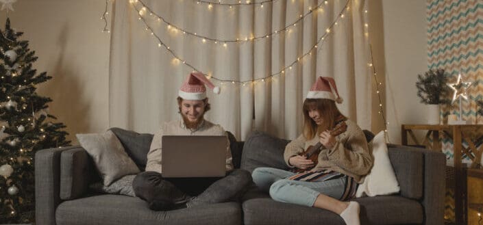 Couple in Santa Hats Sitting on Couch