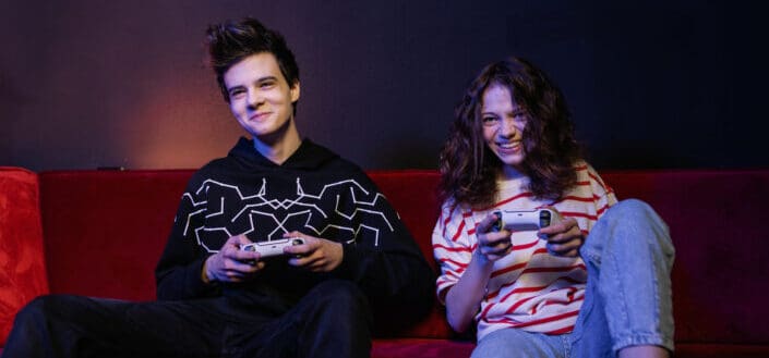 Couple Sitting on Couch Playing Video Games