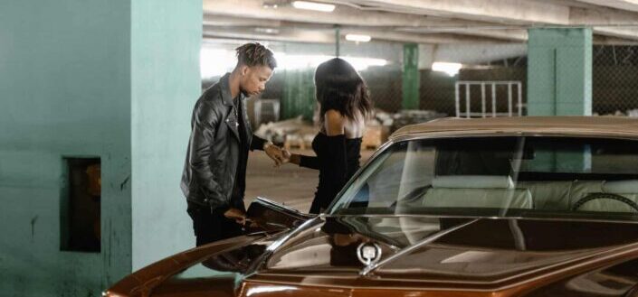 Man helping a woman get out of a car