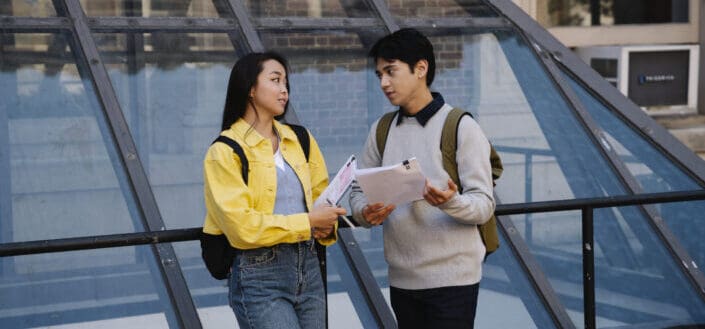 Man Holding Papers While Talking to a Woman