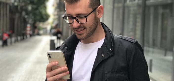 man in black jacket using smartphone