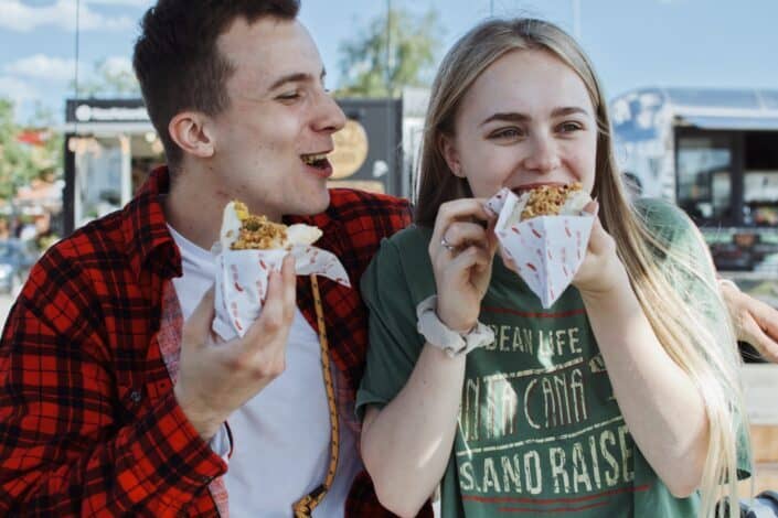 Man and Woman Eating Sandwiches Together