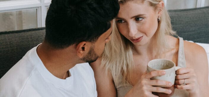 couple having a conversation while holding mug