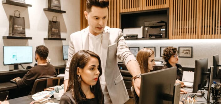 Man Teaching Woman in Front of Computer