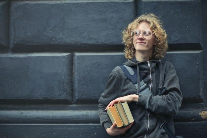 intellectual man holding books near wall - Nerd Jokes