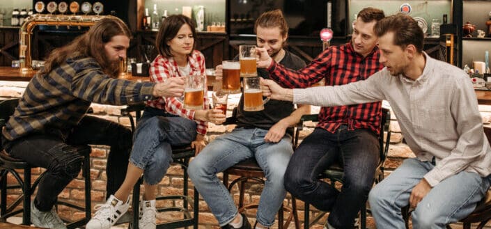 People Toasting Their Mugs With Beer