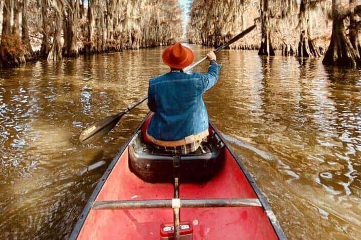 Person Riding Red Canoe Boat