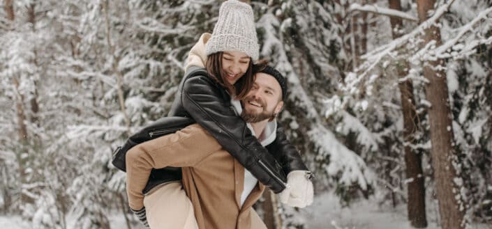 Man Carrying A Woman Through The Snow