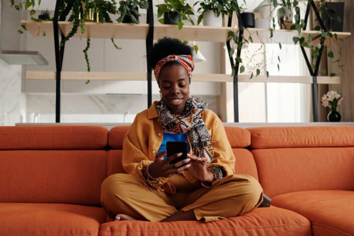 woman using her phone while smiling